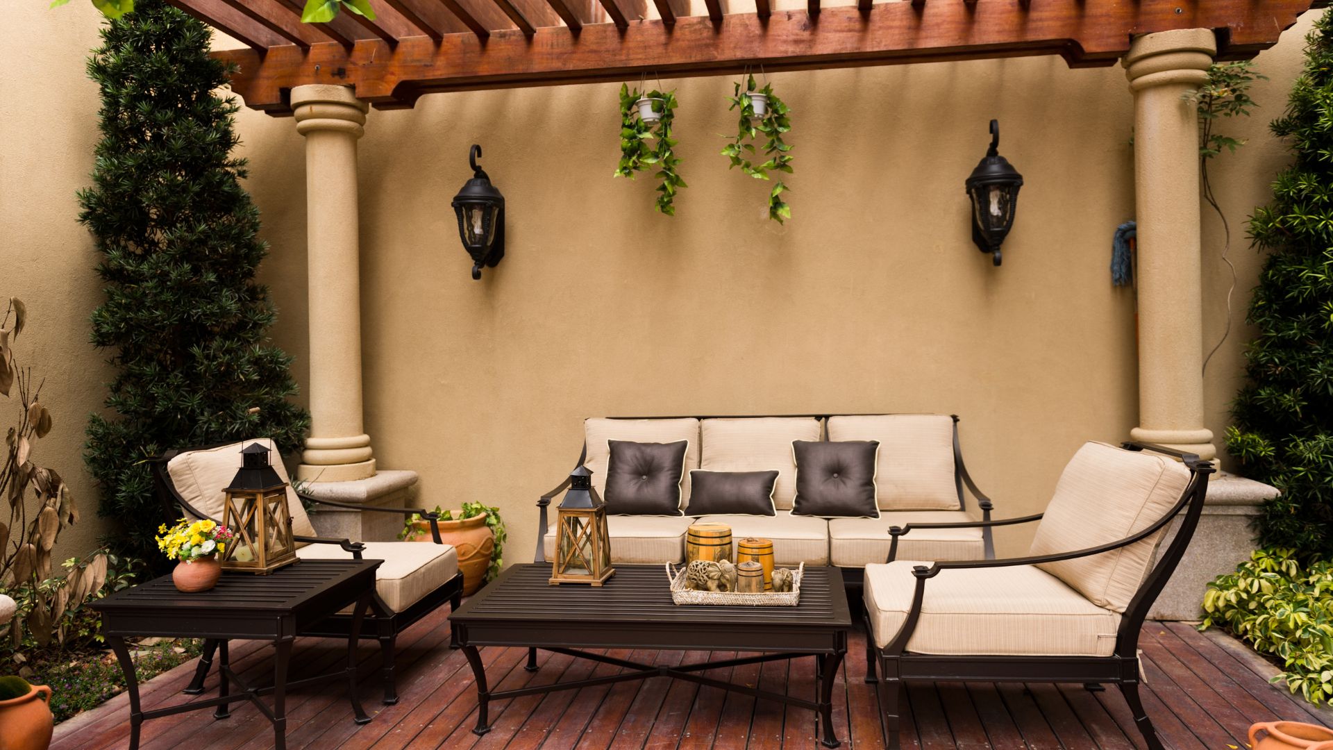 A patio with a couch, table, chairs and potted plants