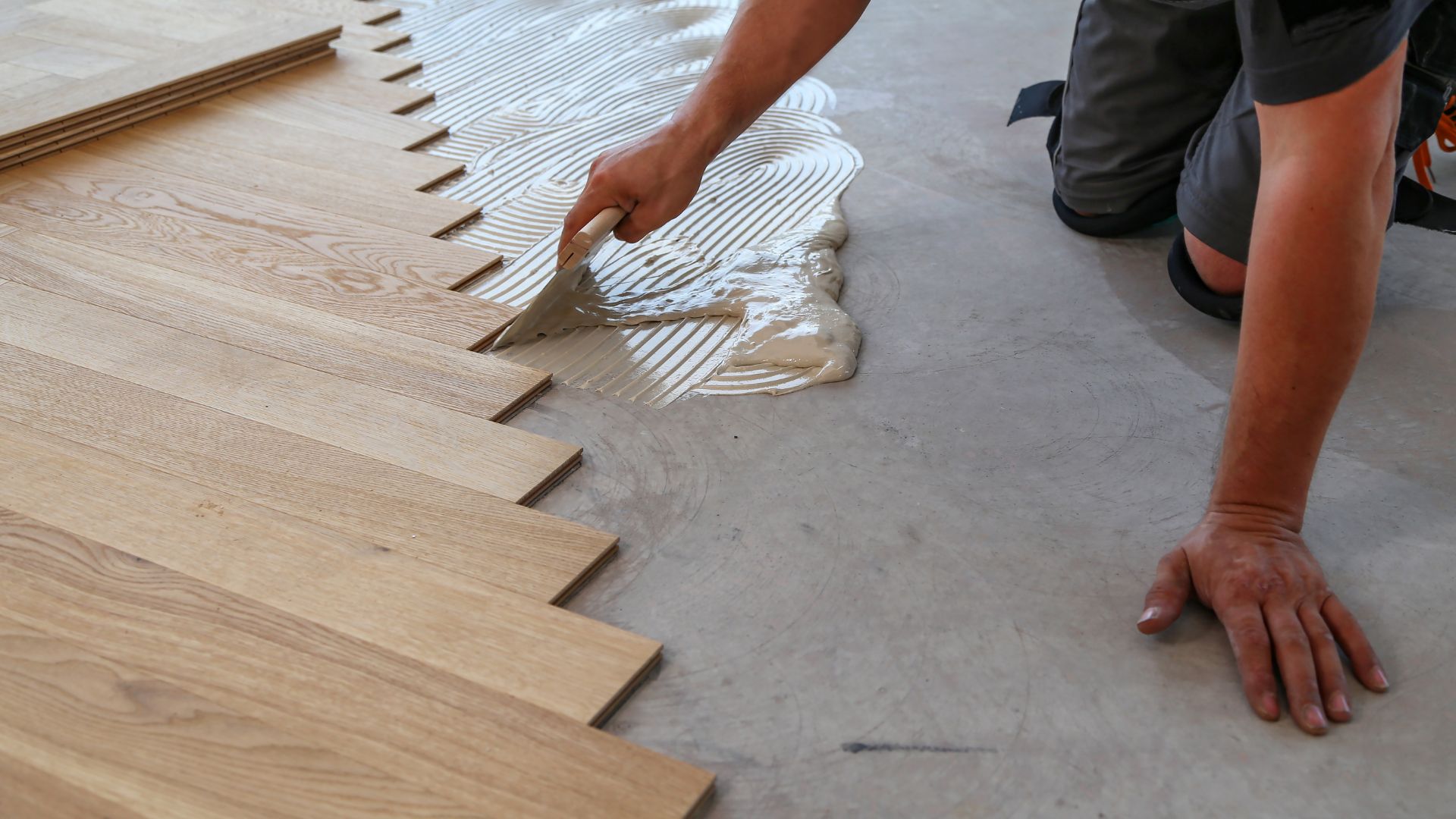 A person laying on the floor with a pair of hands